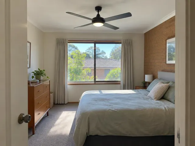 Bedroom ceiling fan in a carpeted room with brick feature wall and window in Garden Suburb